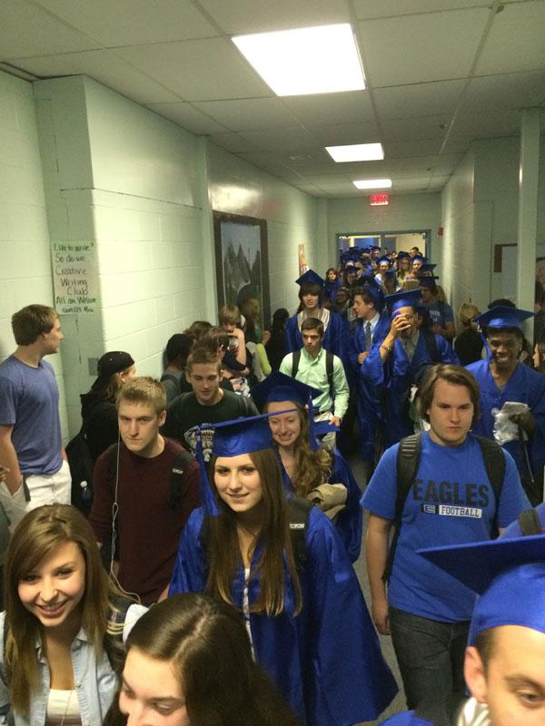 The seniors walked through the hallway with their friends during sixth hour showing off their cap and gowns.