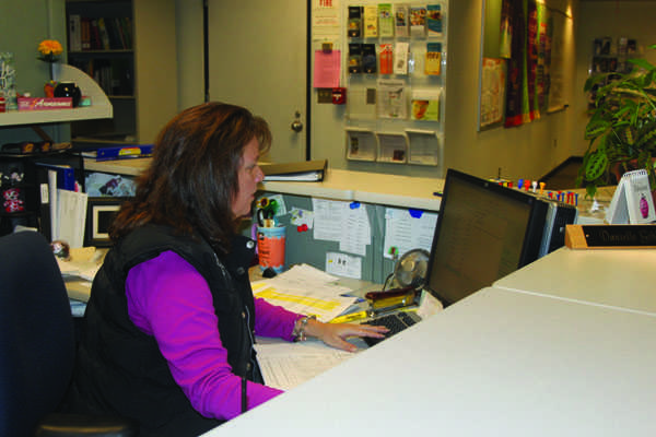 Working on the computer in the counseling office, administrative assistant
Danielle Gibbs works on checking the absences for the day and what students need work sent home to work on.