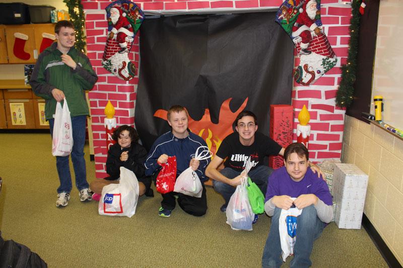 LCCE students sit with their gifts at their handmade fireplace. 