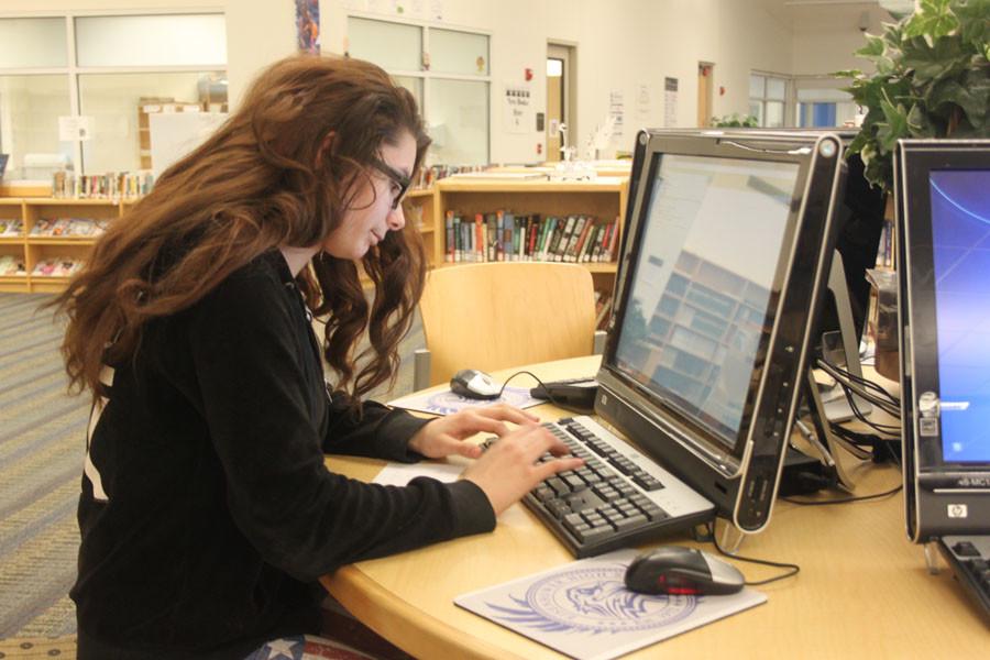 Sophomore Marissa Boyce works in the library on the pilot online testing in order to help herself prepare for the new testing that is coming in the spring. The pilot online testing preparation for the exam has been performed in nearly 1,900 schools in Michigan.