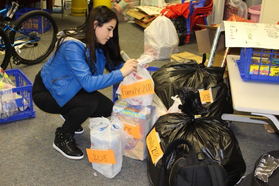 Senior student council representative Christina Atanasoska organizes and prepares the Holiday Sharing gifts for pick-up. It was stressful work but ultimately worth it, Atanasoska said.  She is excited to visit next year and hear about Holiday Sharing 2016.