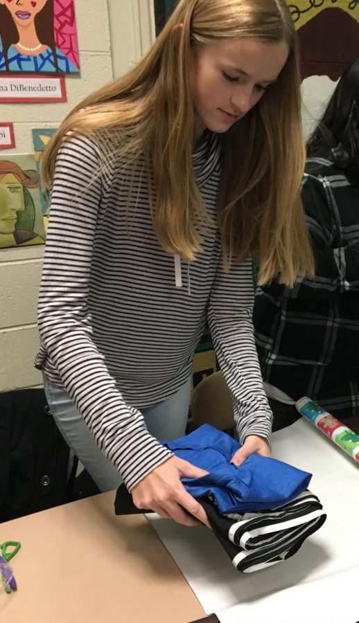 Sophomore Allison Kuzera wraps gifts for the family on Tuesday, Dec.12.