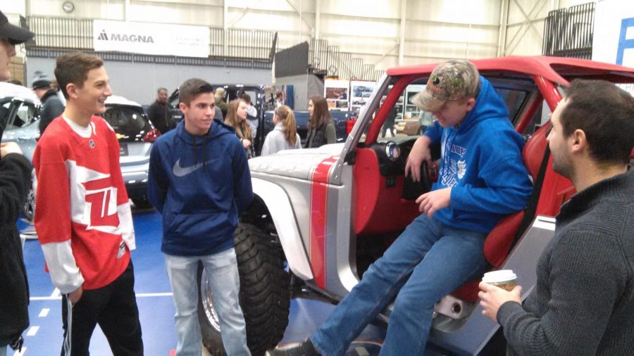 While experiencing automotive design, junior Zachary Polizzi, junior Carson Powers, and senior Ben Fowler discuss the car industry with an event supervisor. 