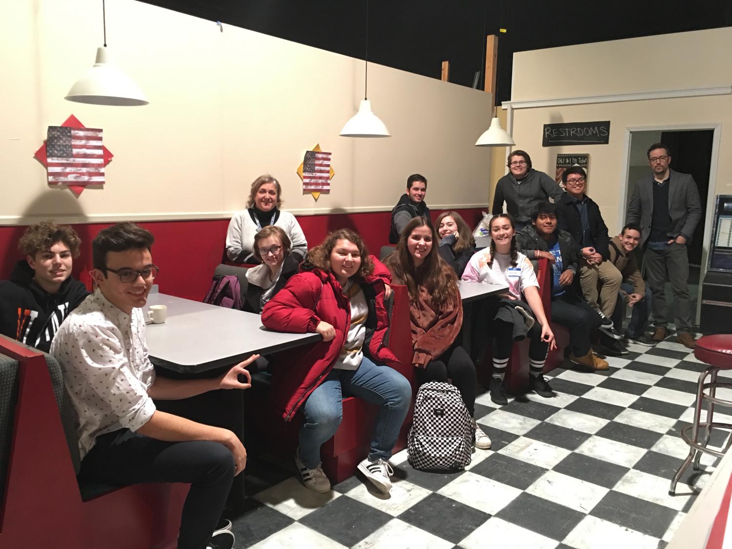 Film teacher Josephine Braun and the students on the trip sit on a movie set.