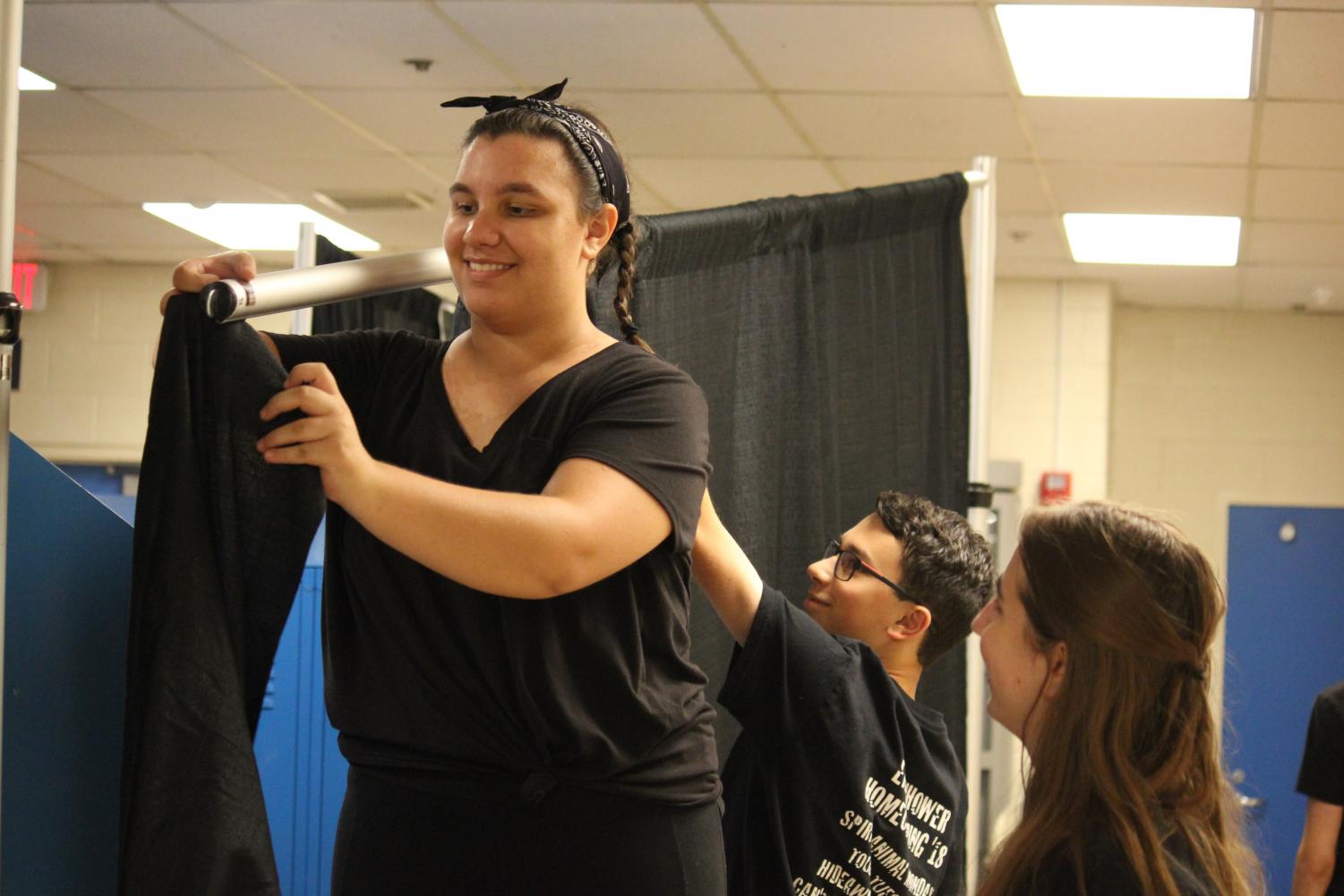Senior Cayla Kadets, junior Stephen Verbanac and junior Jordan Nacker hang up curtains for the 2018-2019 homecoming.