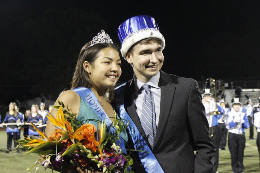 Homecoming king and queen Iain Robb and Carina Hanna pose for photos at the homecoming football game.