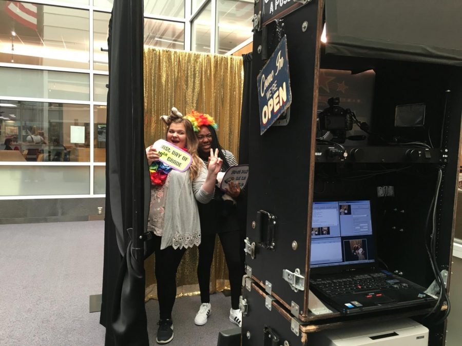 Sophomores Bella Arini and Ayoka Razaki take a picture in the photo booth to remember their first day of 10th grade.