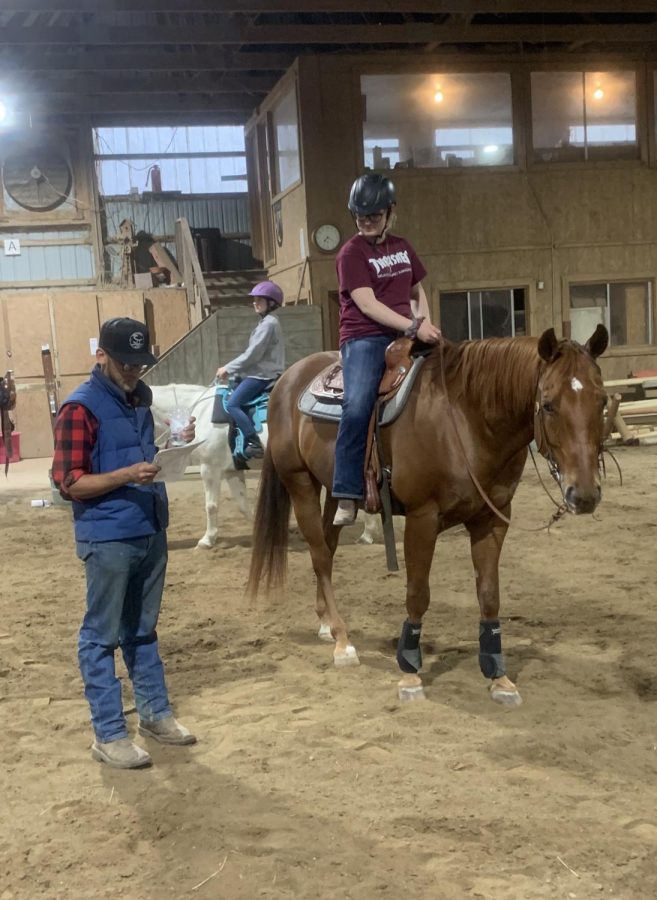 As+coach+Noah+Ballard+reads+off+the+new+pattern%2C+senior+equestrian+Jasmyn+Malmgren+prepares+for+their+Regionals+meet.+%E2%80%9CWe+were+all+super+excited+and+everyone+was+a+little+nervous+because+we+weren%E2%80%99t+really+sure+what+to+expect%2C+but+it+was+awesome+getting+to+see+everyone%2C%E2%80%9D+she+said.+All+that+practice+earned+their+team+a+third+place+at+Regionals.%0A