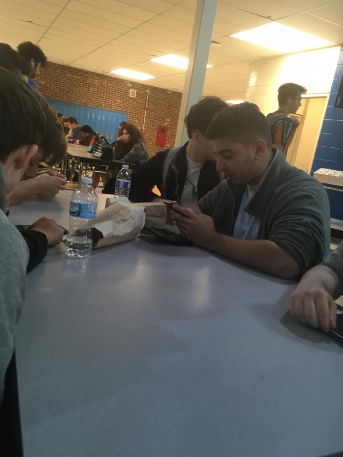 Sebastian games on his phone while with his friends.
Surrounded by his friends, senior Sebastian Grillo immerses himself with the game he and his friends are playing.  “Lunch is a great time to spend with friends doing whatever,” he said. He eliminated school stress with some games.
