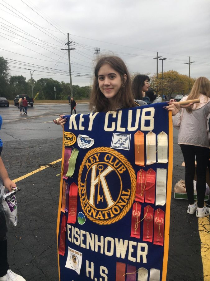 As senior Amanda Davis wait for the parade to start, she gets her key club poster out and ready. She had been in key club for three years and was happy to march in the parade with them one final time. “I like volunteering and giving back; I think its a fun thing to do. I like seeing how impactful it is on other people in the community,” she said. “Im excited to march; its my third year marching for the club and its my last so its kind impactful. Photo and caption credit/ Aurora Strachan.