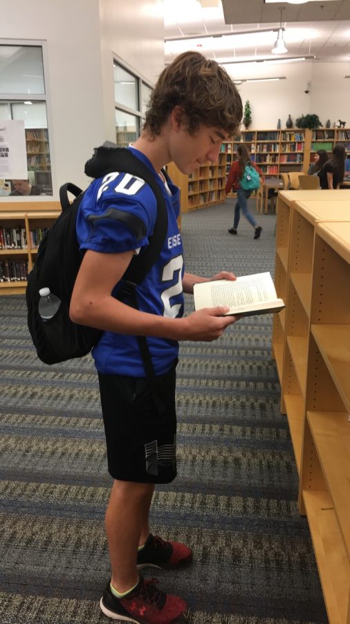 In the media center before the bell rings, sophomore Andrew Langkam checks out a book. “It looked 
interesting to me and I wanted to read it for class,” Andrew said. Andrew chose a book for his english silent reading.
