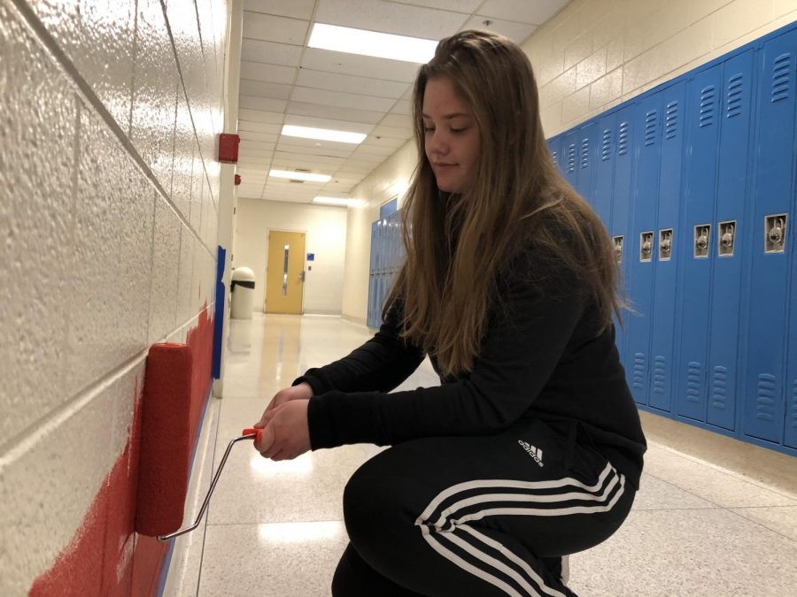 Armed with a crimson painted roller and determination, senior Emily Tschirhart begins the long process of the mural. “The inspiration I got from the Detroit water tower was that it encompasses different animals, just like we encompass different people,” Tschirhart said. Tschirhart spent time after school working on the mural.
