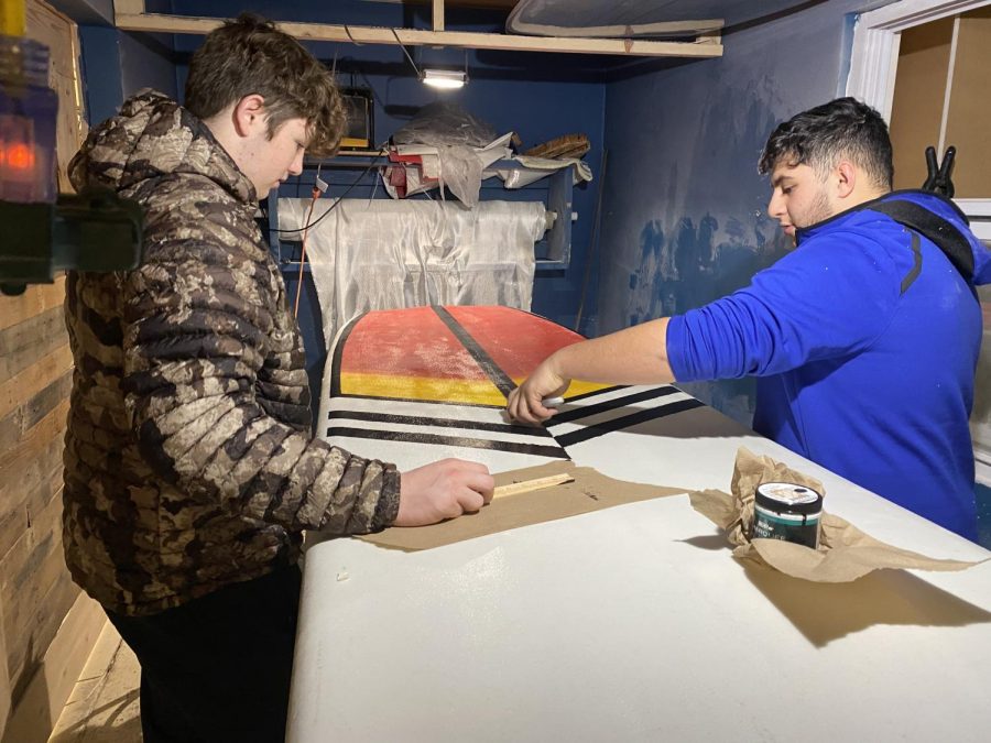 Working on a paddleboard, seniors Austin Vandenbrink and Michael Ammori add finishing touches to the paint. “I love the class; its a lot of fun. It gives you the freedom to do what you want, but you have to actually do something. You dont just get to free roam and not do anything,” Vandenbrink said. Students finished up their boards in class.