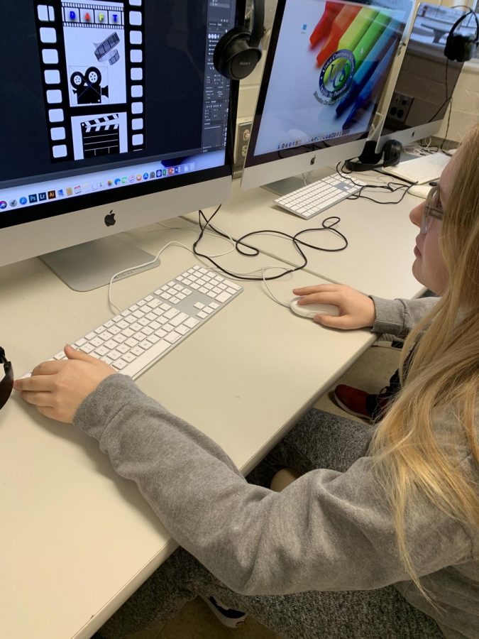  Adding finishing touches to her design, senior Nichole Riley concentrates on making her poster. “I’m most proud of figuring out how to format it, lay it out and create unity throughout the poster,” Riley said. The posters took the place of the multimedia exam. 
