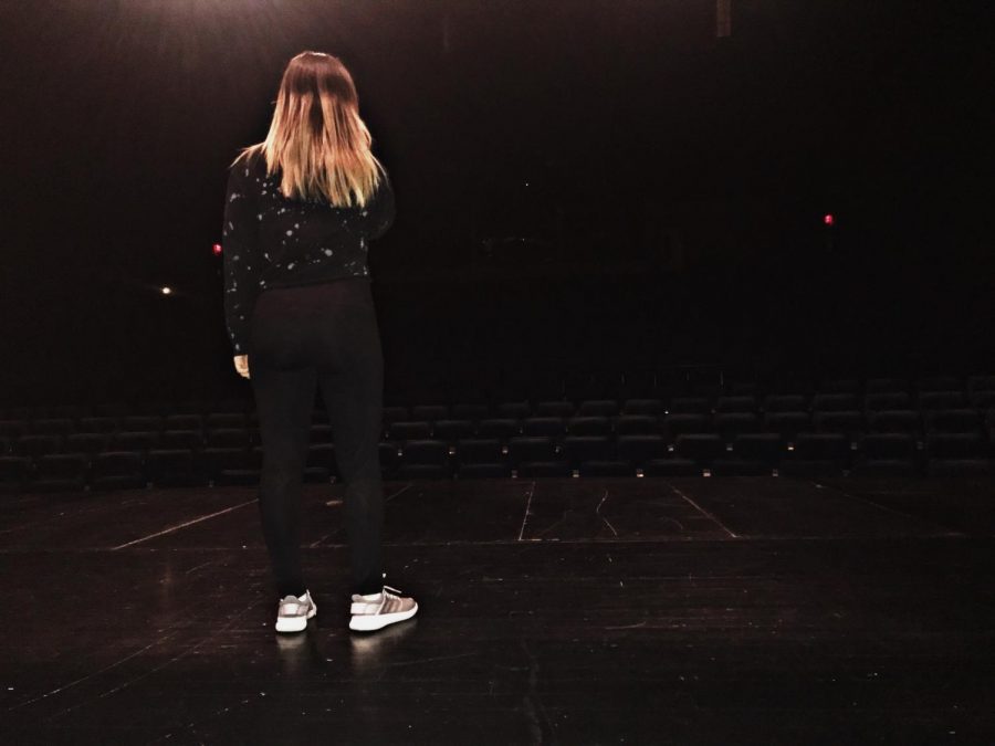 Standing center stage, junior soloist Emily Chriss rehearses her song for the vocal pops concert. “I can get nervous when I’m performing, but I push through the nerves and keep going,” Chriss said. She auditioned with the song “Always remember us this way” this year after being chosen last year to sing in the concert.