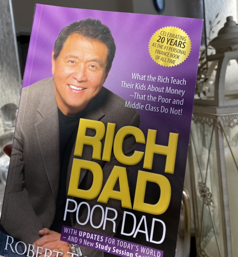 Rightfully+considered+the+%231+Personal+Finance+book+for+more+than+20+years%2C+Rich+Dad+Poor+Dad+by+Robert+T.+Kiyosaki%2C+discusses+what+the+author+had+learnt+from+growing+up+around+two+fathers+with+completely+different+views+on+money+and+in+life+in+general%3B+emphasizing+the+history+and+terminology+behind+the+success+of+acquiring+wealth+explained+in+a+simplistic+yet+approachable+way.