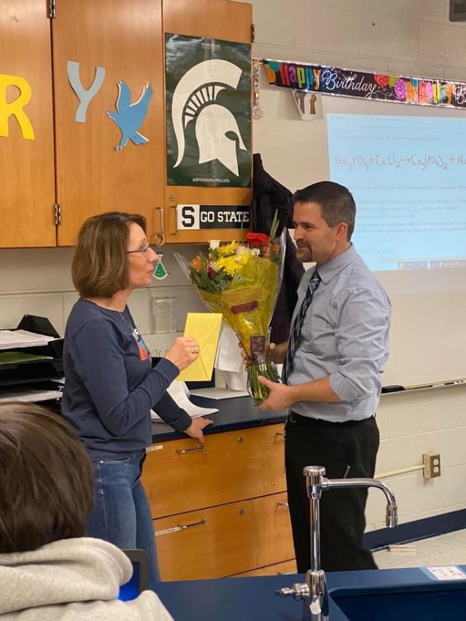Chemistry teacher Melissa Minton recieves a card and flowers from Principal Jared McEvoy. “It took me by surprise, Minton said. Minton was recognized as teacher of the year.