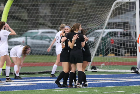 After a nail-biting game, varsity soccer girls rush their teammates to celebrate the big win.