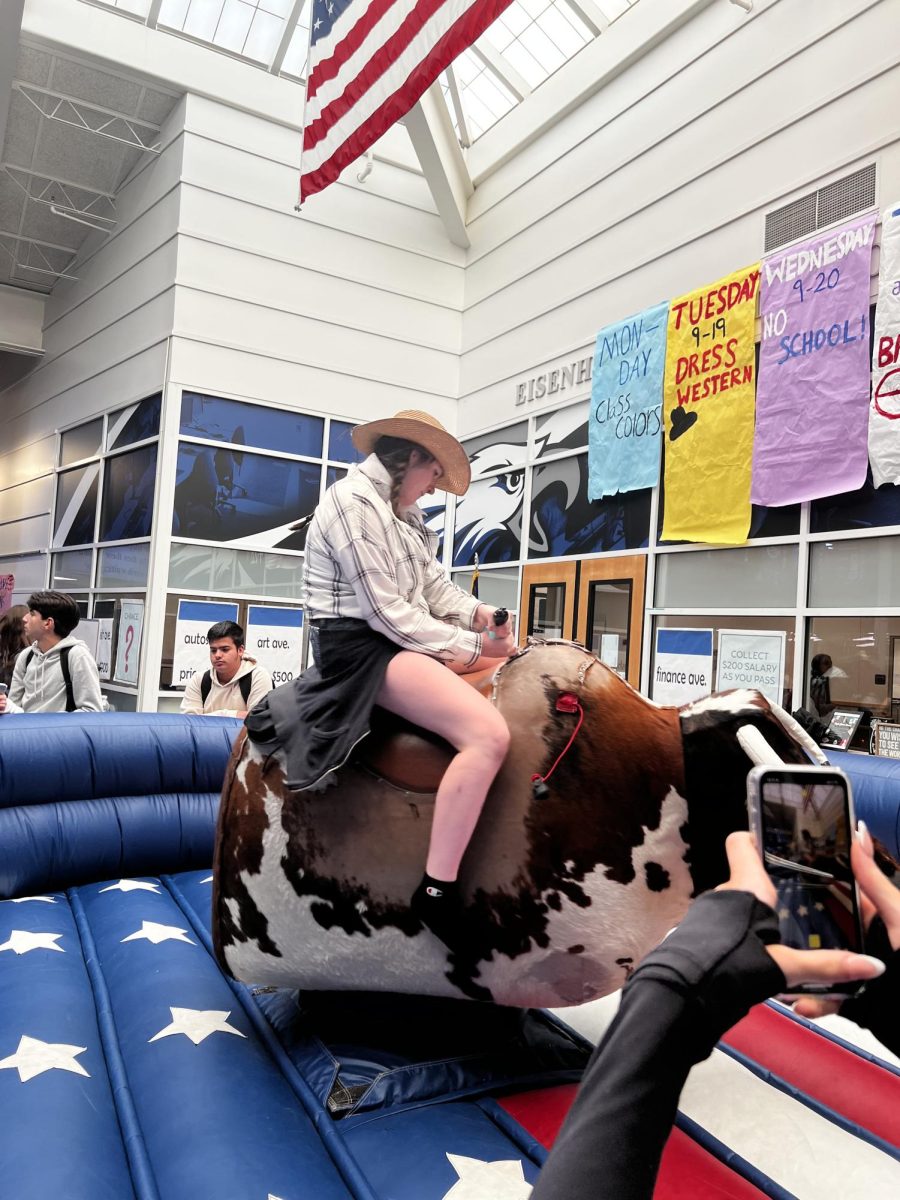 Ride on! Sitting on a mechanical bull during C lunch, sophomore Ashlynn Sakofske participates in western day. “I wish they would have the bull rides every week,” Sakofske said. She liked getting dressed for western day because she thought her outfit was cute.
