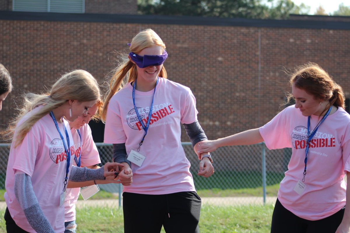 Lead the way. In November 2022, leadership day students senior Abigail Klaft and junior Abigail Pfeffer participated in group activities. During the game the students were blindfolded, and the challenge was to help each other find hidden pieces of tape.

