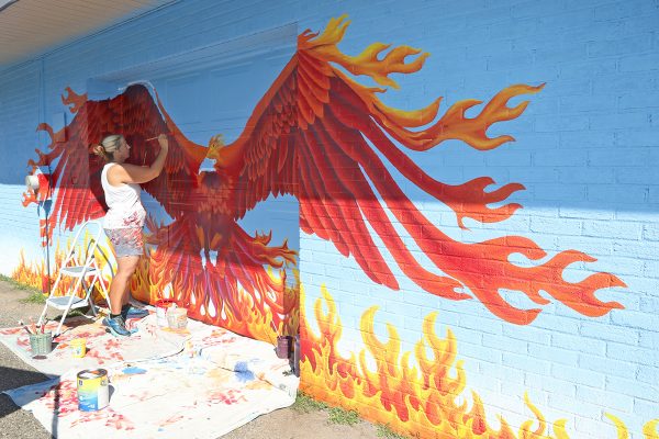 Leaving her mark. Painting a phoenix mural, art teacher Jennifer Ramirez showcases her art. Ramirez was honored by Madison Heights for her artwork around the city.