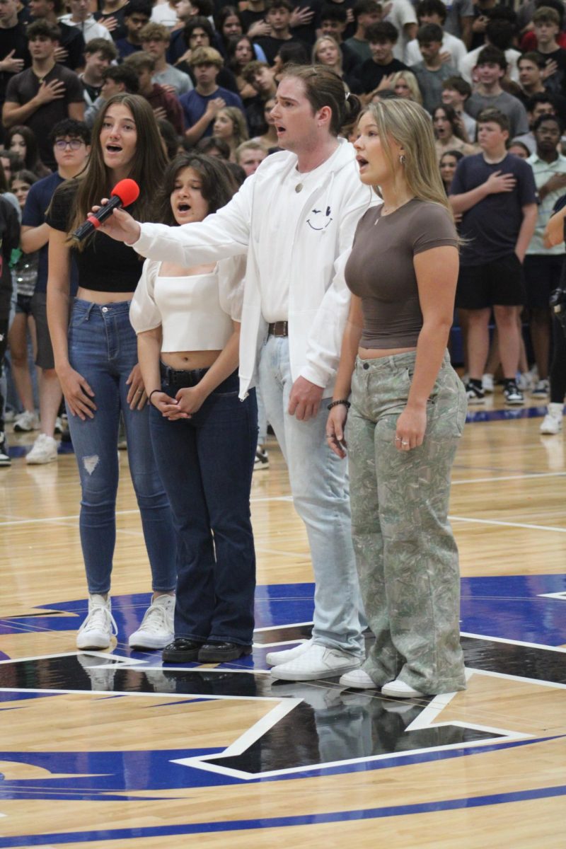 STRIPES AND BRIGHT STARS. As the first pep assembly commences senior choir singers Zoe Mielke, Iris Bremer, Ryan Catey and Raegan McCloud sing the National Anthem.