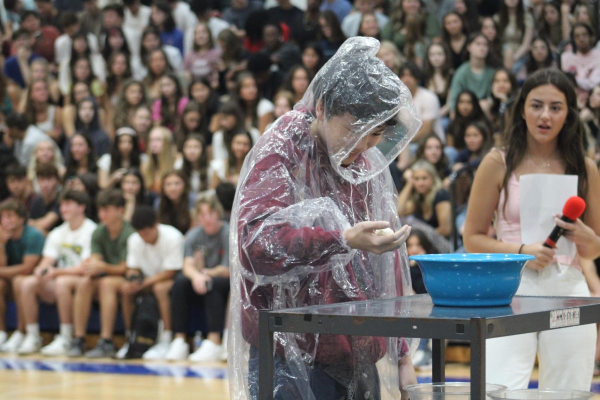 EGG ROULETTE. Towards the end of the pep assembly senior Henry Tran cracks an egg on his head, discovering if it’s hard boiled or uncooked.