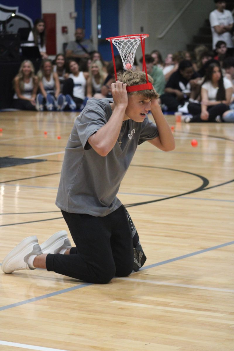 HEAD IN THE GAME. Participating in the pep assembly games, senior Zef Gega attempts to catch a ping pong ball in the net attached to his head. 