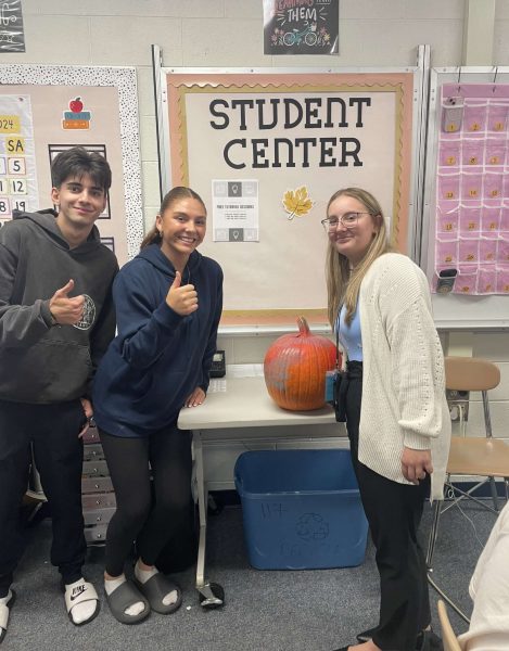 Posing with a pumpkin and seniors Amelia Sweis and Adrian Sinishtaj, English teacher Elsa Pergjoni welcomes the autumn season and colder weather. “[My favorite season is] winter because I love the snow and love being cold. I hate being hot so summer is the worst,” Pergjoni said.
