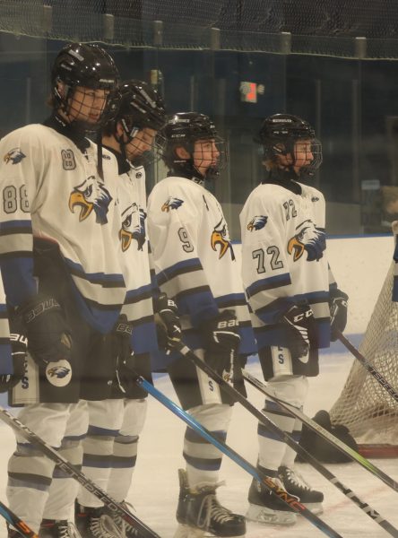 Weston Szudarek and other graduates huddle up together watching the introductions. With nerves taking over they stand there and acknowledge the event that's happening. "I was nervous, it was my first year of hockey but the seniors helped me through it and calmed me down." said Szudarek