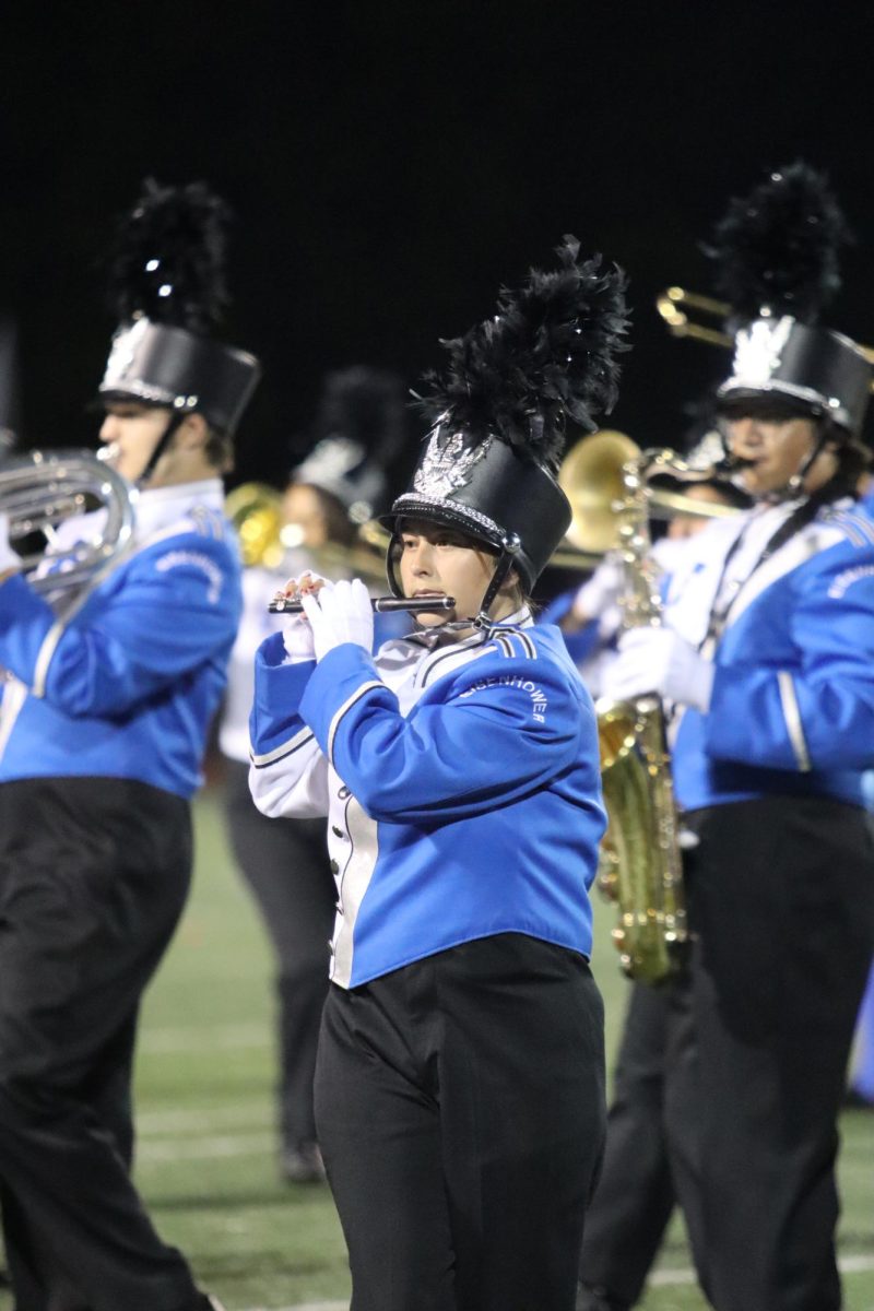 Playing the piccolo, junior Sabrina Stojanovski plays alongside her bandmates at a Friday night football game.  The band performed their routine before the start of the game as well as half time. 