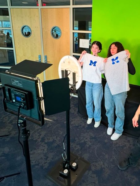 Sophomores Maria Kaci (left) and Reagan Kado (right) hold up their custom-made t-shirts for the camera at the Sophomore college fair.