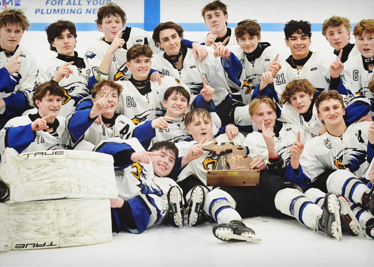 After their exhilarating win, the Varsity hockey team crowds together with their regional trophy. The team beat Romeo 2-0 Wednesday, Feb. 26.