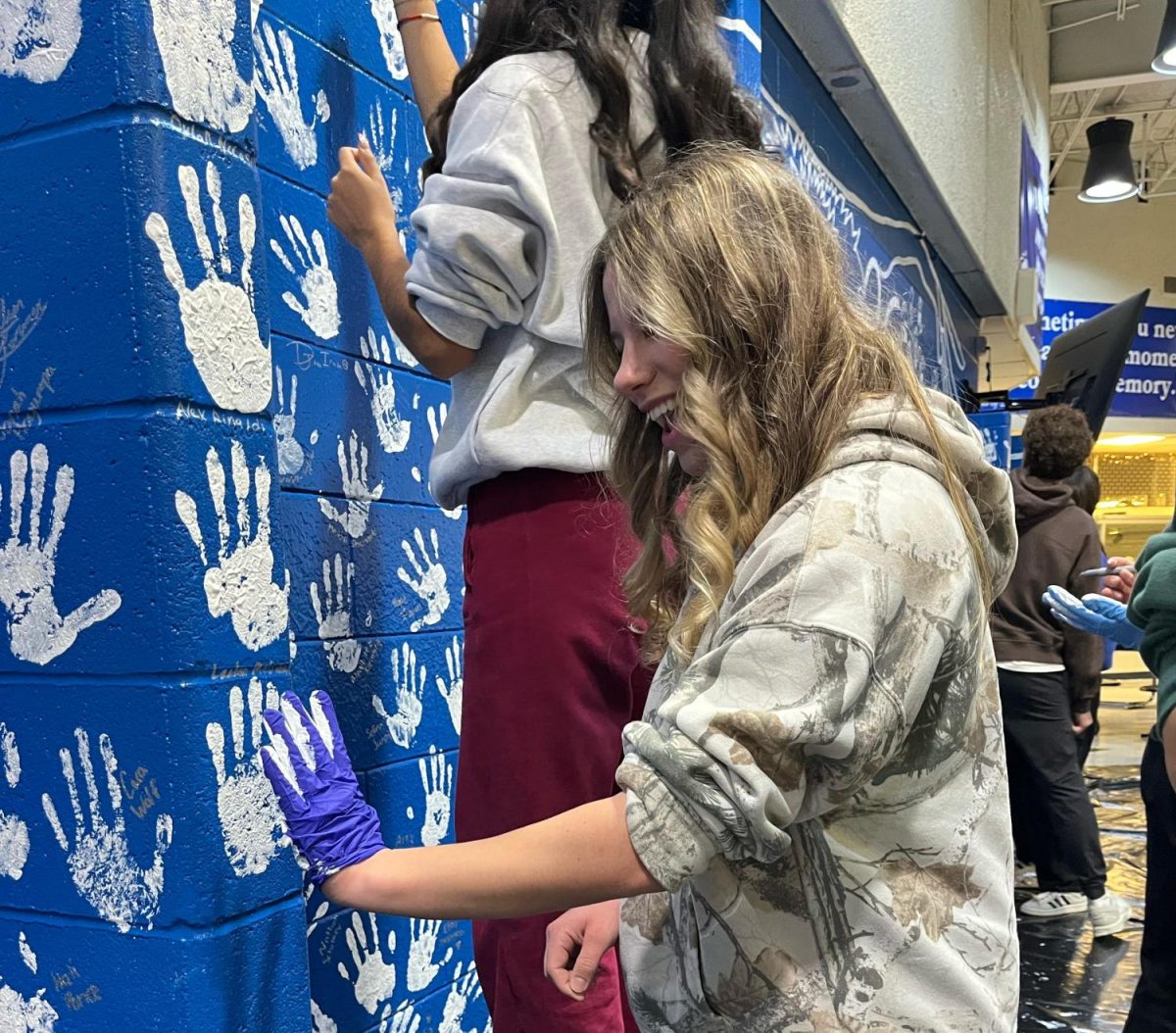 Taking part of the senior experience, senior Sophia Tripi adds her handprint to the wall. Part of the graduating class, Tripi takes part in a 24-year-old tradition. “My favorite part was just seeing my friends and everyone being excited as we’re seniors now,” she said.
