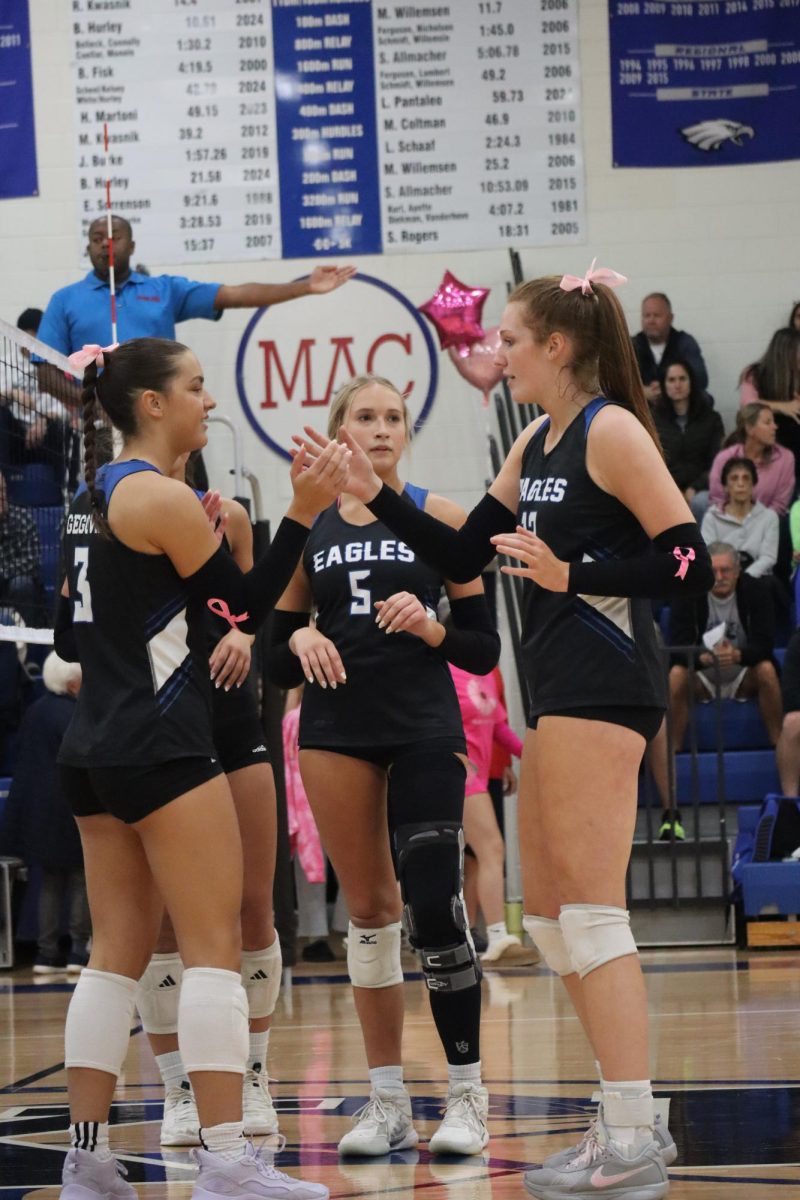 During a varsity volleyball game, junior Lilliana Tripi and senior Liliana Gegovic celebrate their point. "The handshake is like a reset. It's either us celebrating after each point or for us to keep going. It just puts us in a good mood," Trippi said.